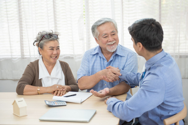 smiling-satisfied-senior-couple-making-sale-purchase-deal-concluding-contract-hand-get-house-key-from-real-estate-agent-happy-older-family-broker-shake-hands-agreei